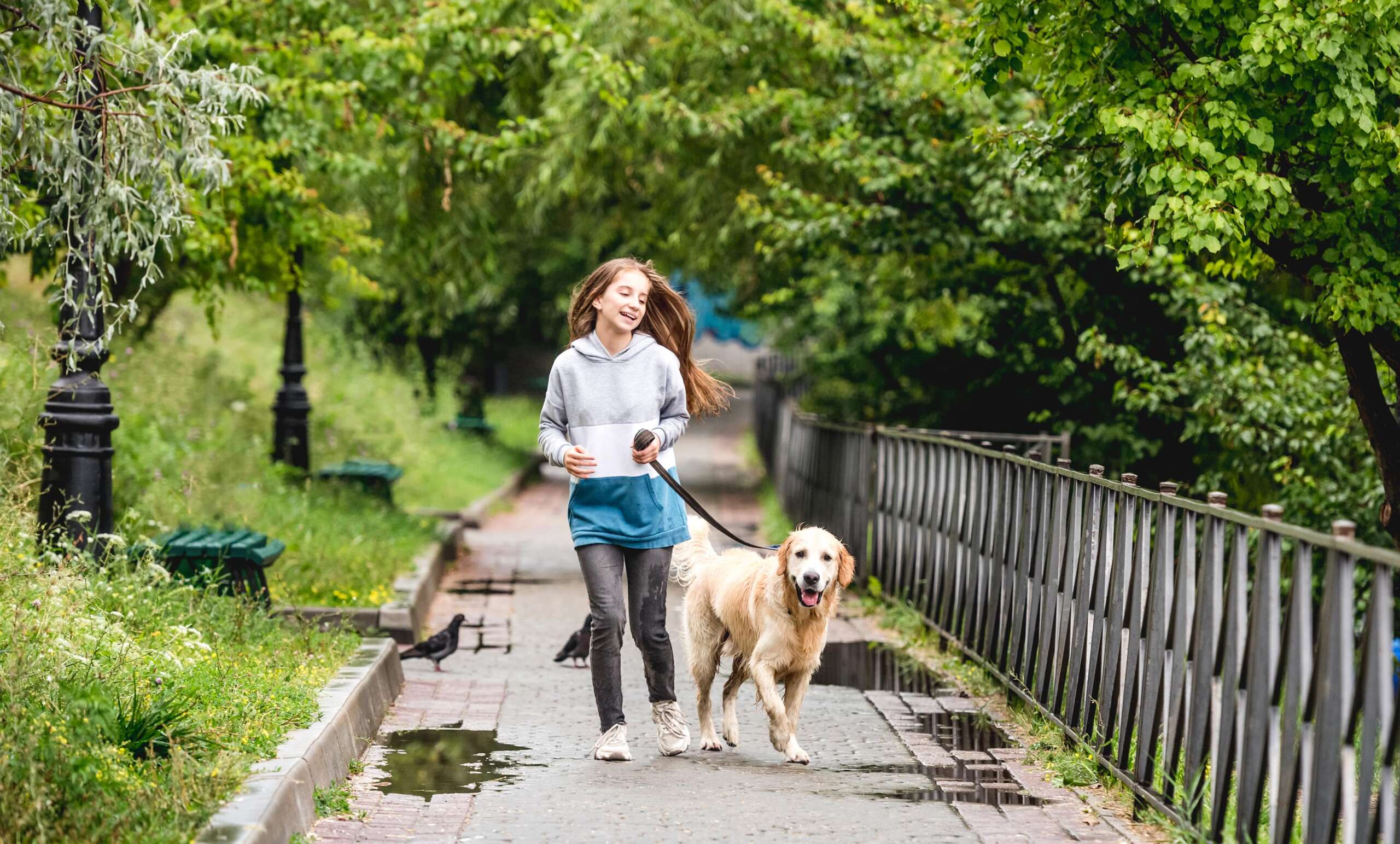 teenage-girl-running-with-dog-after-rain-2023-02-02-03-28-16-utc-min